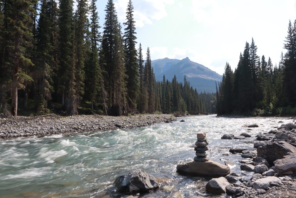 Stone cairn beside a rushing mountain river